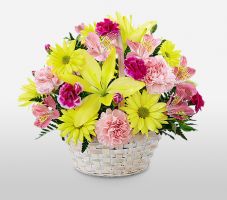 Vibrant round floral basket: Features lilies, roses, and carnations with greens and ribbon.